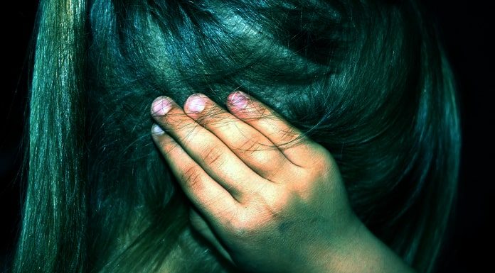 criança vista de lado com as mãos nos ouvidos; mãe abusava da filha e deixava namorados também abusarem