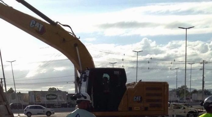 retroescavadeira e operário em rua ao lado da obra de manutenção da adutora da casan