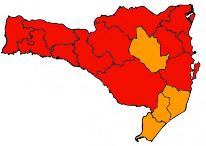 Desenho do mapa de Santa Catarina com 16 divisões de regiões, sendo quatro em cor laranja e dez em cor vermelha. O mapa representa a nova matriz de risco à Covid-19 do estado.