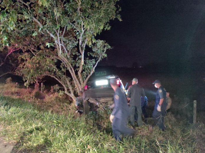 celta batido ao lado de árvore onde mulher morreu na sc 405; três bombeiros em volta; foto noturna