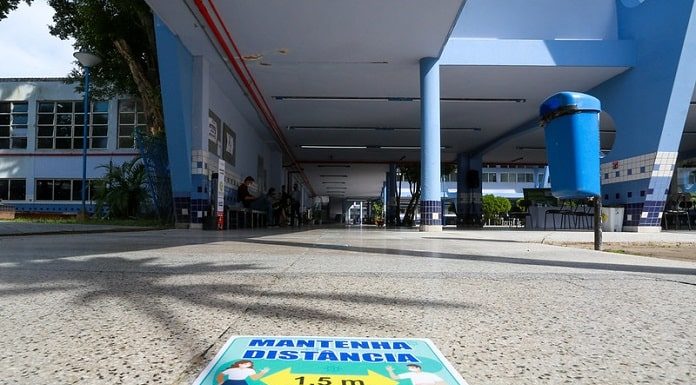 cartaz colado no chão informa sobre necessidade de alunos manterem distanciamento nas escolas para o retorno às aulas; chão do IEE