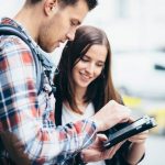 homem e mulher jovens olham para um tablet - Vagas