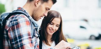 homem e mulher jovens olham para um tablet - univali oferece vagas sem vestibular