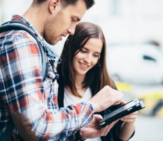 homem e mulher jovens olham para um tablet - Vagas