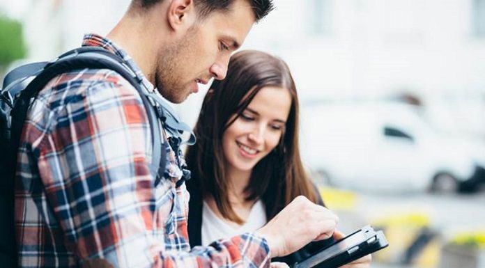 homem e mulher jovens olham para um tablet - Vagas