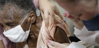 vacina em idosos com mais de 90 anos em florianópolis será em casa - idosa é vacinada no braço, ela usa máscara