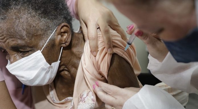vacina em idosos com mais de 90 anos em florianópolis será em casa - idosa é vacinada no braço, ela usa máscara