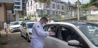 profissional de saúde ao lado de carro em fila de drive no dia em que são josé vacinou 25% dos idosos com mais de 85 anos