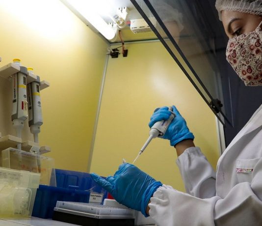 SC tem mais de 200 pessoas infectadas com a varíola dos macacos pesquisadora usando trajes de proteção mexe em ampolas de estudo sobre nova variante do coronavírus