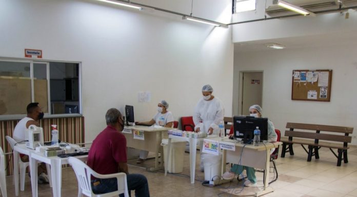 dois homens aguardam em cadeiras por atendimento no Centro de Referência de Sintomáticos