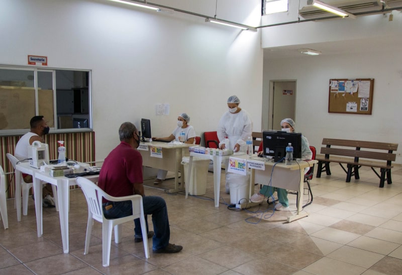 dois homens aguardam em cadeiras por atendimento no Centro de Referência de Sintomáticos