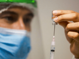 Santa Catarina tem mais de 323 mil doses aplicadas contra a Covid-19 Santa Catarina tem 323 mil doses aplicadas contra Covid-19: Profissional da saúde, equipado com EPI, colocando a vacina na seringa