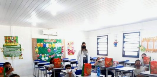 professora em sala de aula com alguns alunos em carteiras, todos de máscara - justiça anula a suspensão de aulas na grande florianópolis