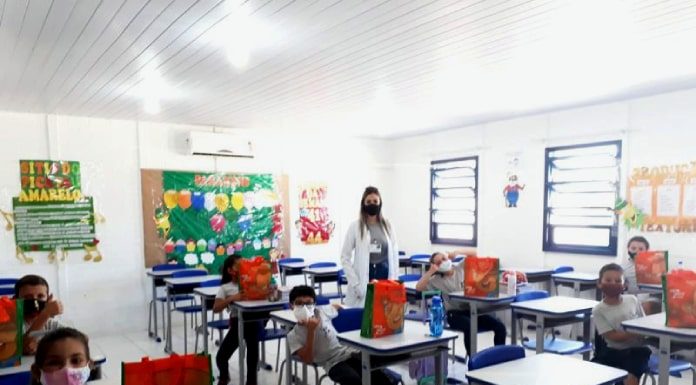 professora em sala de aula com alguns alunos em carteiras, todos de máscara - justiça anula a suspensão de aulas na grande florianópolis