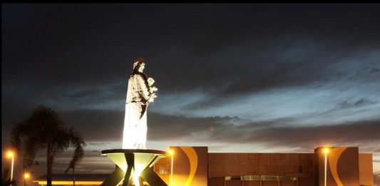 Valei-me, São José! padroeiro são josé iluminado à noite ao lado do centro multiuso na avenida beira-mar