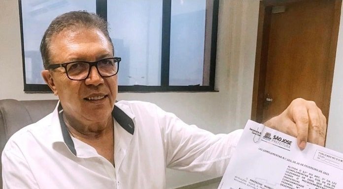 prefeito orvino segura documento mostrando para a foto com a lei de isenção de taxas para MEI