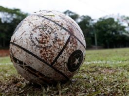 Alteração em decreto autoriza prática de esportes recreativos em SC Uma bola branca suja de barro e ao fundo um campo de grama. A foto ilustra a alteração do governo no decreto de medidas restritivas, agora os esportes recreativos estão autorizados em SC.