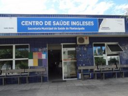 Centro de Saúde dos Ingleses, em Florianópolis. Identificado em letras brancas com fundo azul claro, tem azulejos azuis escuros na parede