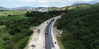 foto aérea de trecho da rodovia perto de mata e máquinas na pista parcial de asfalto - Contorno Viário: consórcio busca mão de obra local