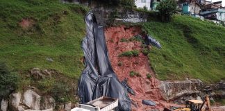 Imagem de deslizamento de terra em trecho da Via Expressa em Florianópolis. Há um caminhão e carros de suporte da pista. Florianópolis e São José registraram quase 100 ocorrências relacionadas às chuvas nesta segunda-feira