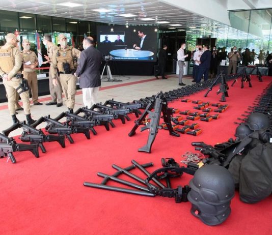 Alesc destina mais de R$ 11 milhões para viaturas e armas da Polícia Militar No tapete vermelho da Alesc os armamaentos estão distribuídos lado a lado. Ao fundo da foto pessoas reunidas e mais a frente um grupo de policiais militares fardados. A Polícia Militar de SC recebeu hoje viaturas e equipamentos em ato simbólico na assembleia.