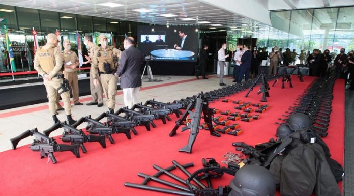 No tapete vermelho da Alesc os armamaentos estão distribuídos lado a lado. Ao fundo da foto pessoas reunidas e mais a frente um grupo de policiais militares fardados. A Polícia Militar de SC recebeu hoje viaturas e equipamentos em ato simbólico na assembleia.