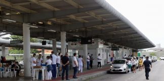 estação palhoça, onde é feita a vacinação por drive-thru; profissionais de saúde na plataforma; fila de carros; policial na pista