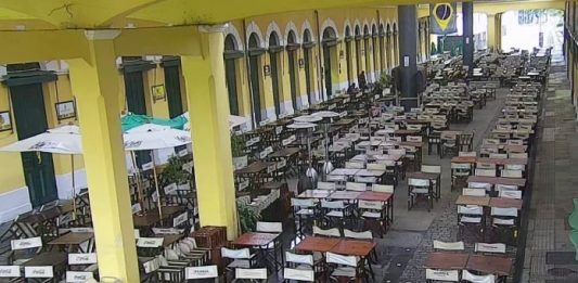 Governo estadual proíbe consumo de bebida alcoólica no local de venda à noite vista do vão central do mercado público de florianópolis com mesas e cadeiras vazias - governo restringe consumo de bebidas alcoólicas