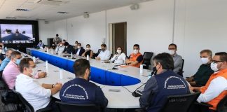 prefeitos reunidos em grande mesa em formato de "U" na instalação do Centro Integrado de Ações Contra a Covid; todos de máscara