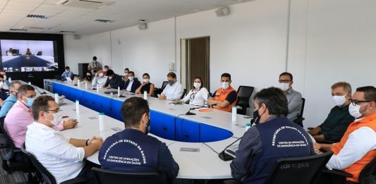 Sem consenso, estado cria o Centro de Ações contra Covid da Grande Florianópolis prefeitos reunidos em grande mesa em formato de "U" na instalação do Centro Integrado de Ações Contra a Covid; todos de máscara