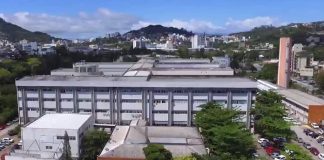 Visão de cima do HU/UFSC. Aprecem algumas árvores e prédios ao fundo. O Hospital tem alguns prédios lado a lado, o que aparece na frente tem cor cinza e branco. Nesta semana, o HU fechou a emergência pediátrica para atender adultos em estado crítico da Covid.