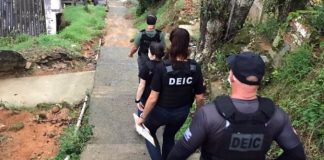 quatro agentes da policia civil (dois homens e duas mulheres) usando coletes da corporação descem por rampa em área inclinada; são vistos de costas - deflagração da operação network 2