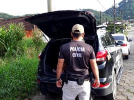 Polícia Civil faz nova operação contra o PCC em SC para prender 34 policial civil atrás de uma caminhonete da pc com porta-malas aberto estacionada em rua de paralelepípedo na deflagração da operação rescaldo