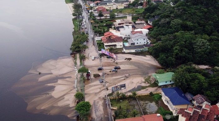 foto área do rompimento da lagoa da casan na lagoa da conceição, com grande massa de areia sobre avenida e invadindo a lagoa