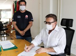 São José destina R$ 1,3 milhão para a área do esporte de rendimento Sentado em uma cadeira preta, o prefeito Orvino usa camisa branca de manga comprida, além de óculos de armação preta e máscara branca. Ele assina um convênio que destina mais de R$ 1 milhão para a área do esporte em São José. Próximo a ele, em pé, um dos representante da área acompanha a assinatura, ele usa óculos de grau, máscara branca e camiseta preta.
