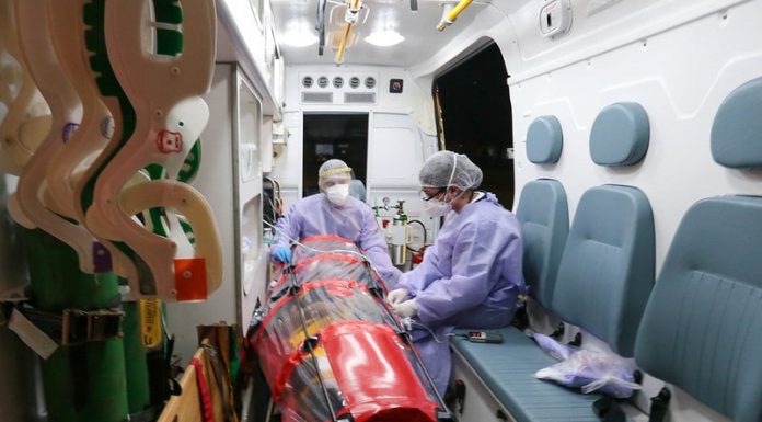 paciente em capsula dentro de ambulância com duas profissionais de saúde trajadas de EPI - pacientes serão transferidos de SC para o espírito santo