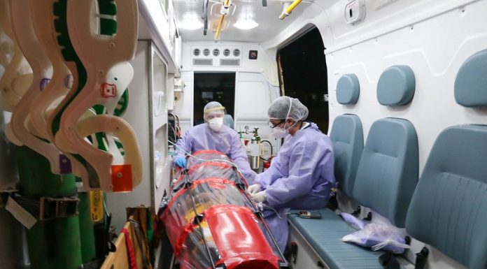 paciente em capsula dentro de ambulância com duas profissionais de saúde trajadas de EPI - pacientes serão transferidos de SC para o espírito santo