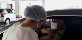 profissional de saúde aplica dose em braço de homem dentro de carro - São José inicia vacinação de idosos de 76 e 77 anos