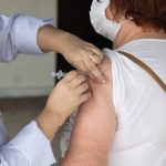 profissional de saúde aplica injeção no braço de senhora - vacinação de idosos em são josé