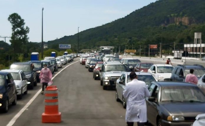 fila de carros em ponto de drive-thru - vacinação de idosos de 67 e 68 anos em Florianópolis