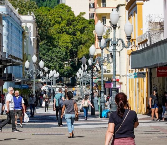 SC volta a apresentar aumento nos casos ativos de coronavírus pessoas de máscara andando em calçadão do centro de florianópolis - boletim da Fiocruz diz que pandemia no sul vai piorar