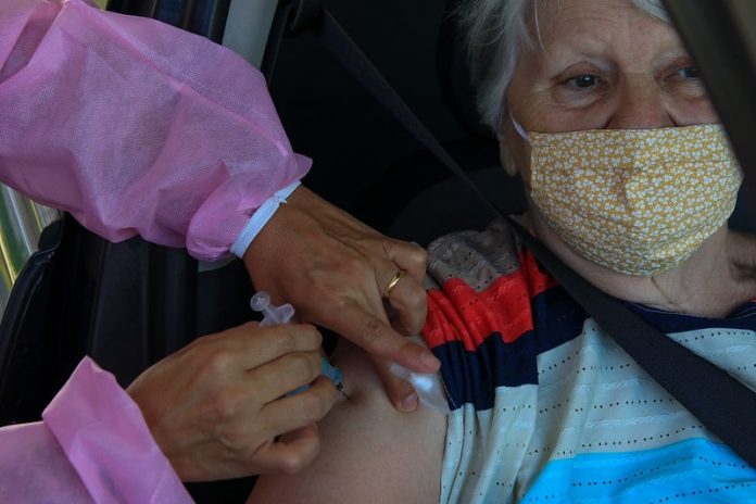 idosa é vacinada no braço dentro de carro -
