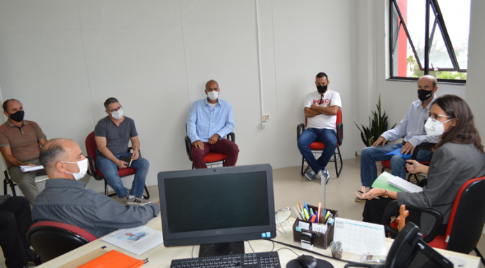 Na foto se vê sete pessoas sentadas em cadeiras e em círculo, elas estão afastadas e usam máscaras. A reunião da defensoria pública com a prefeitura e moradores das ocupações da Boa Vista e Vale das Palmeiras, em São José, discutiu a situação dos moradores das localidades.