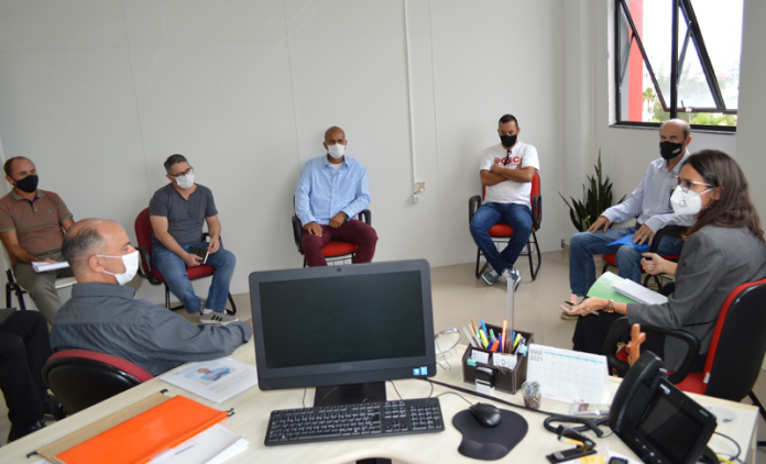 Na foto se vê sete pessoas sentadas em cadeiras e em círculo, elas estão afastadas e usam máscaras. A reunião da defensoria pública com a prefeitura e moradores das ocupações da Boa Vista e Vale das Palmeiras, em São José, discutiu a situação dos moradores das localidades.