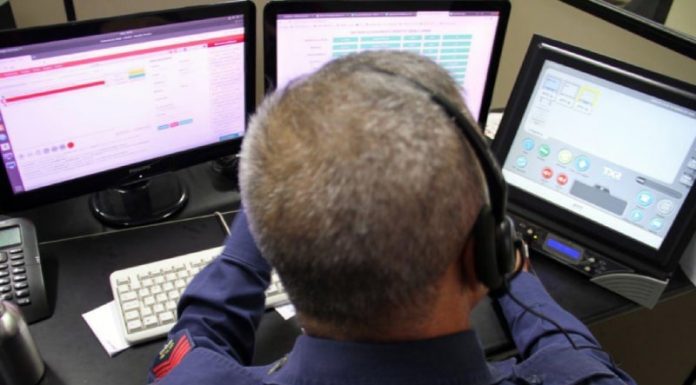atendente telefônico na central dos bombeiros em frente a três monitores - bombeiros recebem muitos trotes