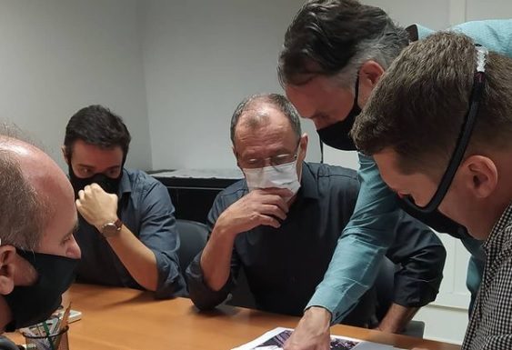Vereador participa de procura por novo local de rodoviária em São José homens reunidos em volta de uma mesa, usando máscaras, olham e apontam para papeis com projetos