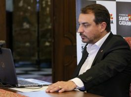 Julgamento do impeachment de Moisés será em 7 de maio - governador sentado à frente de notebook