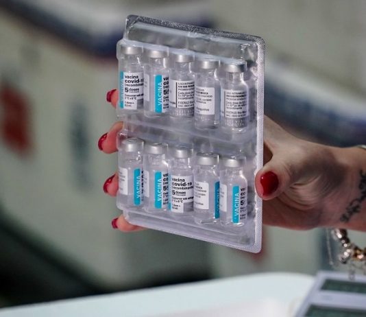 Governo planeja vacinação em massa em cidades de SC com altas taxas de Covid mulher segura doses de vacinas presas em tablete de transporte - novo lote de vacinas chega em sc com 229 mil doses