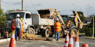 cones, operários, caminhão e retroescavadeira em rua onde há obra de ampliação da rede de gás natural