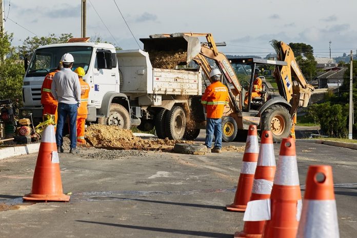 cones, operários, caminhão e retroescavadeira em rua onde há obra de ampliação da rede de gás natural